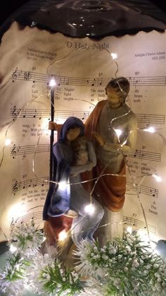 a lighted nativity scene with figurines and sheet music