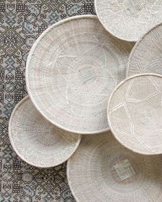 woven baskets are stacked on top of each other in the middle of a carpeted area