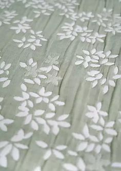 an image of a bed with white flowers on the sheets and linens that are made to look like leaves