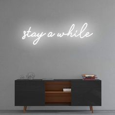 'Stay a while' Neon Sign NeonPilgrim Neon Light Sayings, Stay Awhile Neon Sign, Neon Living Room Sign, Clever Neon Signs, Neon Sign Phrases, Neon Sign Ideas Words, Neon Sign Interior, Led Sign Living Room, Neon Sign In Living Room