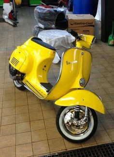 a yellow scooter is parked in the middle of a tile floored area