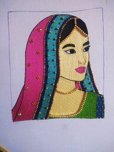 an embroidered portrait of a woman with blue and pink hair