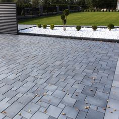 a brick patio with gravel and trees in the background