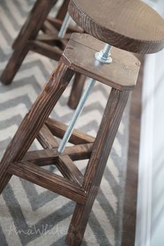 two wooden stools sitting next to each other on top of a carpeted floor