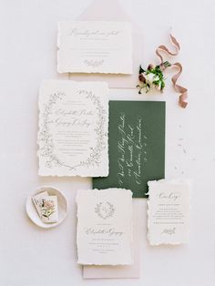 the wedding stationery is laid out on top of each other