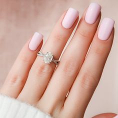 a woman's hand with pink manicured nails and a diamond ring