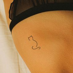 a woman with a cat tattoo on her lower back