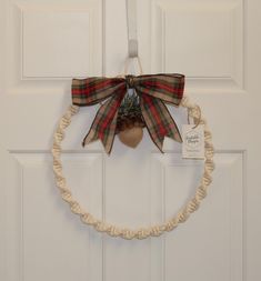 a wreath with a bow hanging on the front door