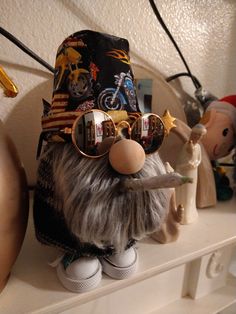 a stuffed animal with sunglasses and a hat on it's head sitting on a shelf