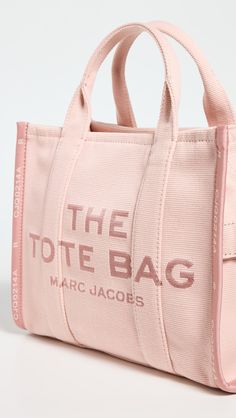 CanvasLogo lettering Structured baseZip closureOptional, adjustable strapTextile liningWeight: 24oz / 0.68kgImported, VietnamThis item cannot be gift-boxedStyle #MJADB34026 Sac Marc Jacobs, Marc Jacobs Sac, Medium Tote Bag, Fabric Logo, Marc Jacobs Tote, Small Tote Bag, The Tote Bag, Medium Tote, Sneaker Wedge