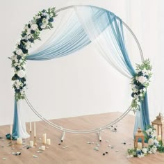 a white and blue wedding arch decorated with flowers