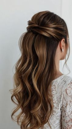 a woman with long wavy hair wearing a half updo