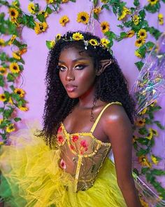 a woman in a yellow dress with sunflowers on her head and flowers around her neck