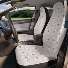 the interior of a car with daisies on pink and white seat covers in front of it