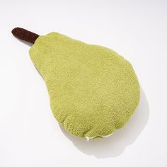 a green stuffed animal sitting on top of a white table next to a brown handle