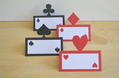 three cards with hearts and spades on them sitting on top of a wooden table