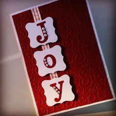 a red and white card with the word joy on it