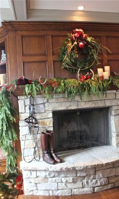 a fireplace decorated for christmas with greenery and decorations on the mantel above it