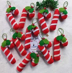 red and white candy canes with green leaves on them are arranged in the shape of christmas stockings