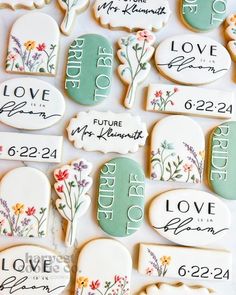 decorated cookies with names and flowers are on a white tablecloth that says, love is in the air