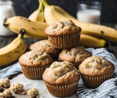 muffins and bananas on a table next to milk