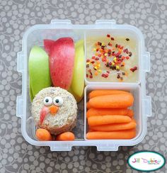 a lunch box with carrots, apples, and an owl made out of rice krispy kreme