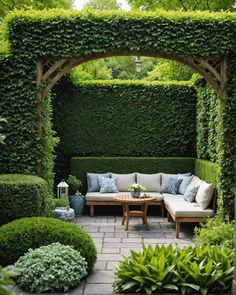 an outdoor seating area with couches and tables surrounded by greenery on either side