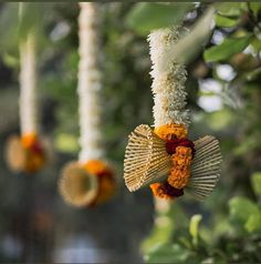 some flowers are hanging from the branches of trees in front of other plants and decorations