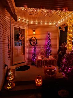 halloween decorations on the front porch with purple lights and jack - o'- lanterns