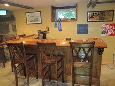 a bar with four stools in a basement