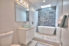 a bathroom with a tub, toilet and sink in it's center wall is shown