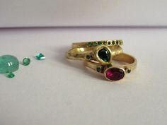 Rings detail: Ring 1: * The ring made from 14k solid yellow gold. * 1 Ruby 4x6mm. * 2 Emerald 0.02ct, 0.01ct each. * Ring thickness 2-3mm. Ring 2: * The ring made from 14k solid yellow gold. * 1 Green tear-drop Emerald. * 1 Small Green Emerald 0.01ct. Ring 3: * The ring made from 14k solid yellow gold. * 15 Emeralds 0.18ct. * Ring width 2mm. Unusual & Very unique combination of three handmade gold rings. A combination of colors Red/Green/Yellow, Rubies and Emeralds stones, solid Yellow gold Gold Stackable Rings With Ruby Bezel Setting, Gold Three Stone Stackable Rings As Gift, Fine Jewelry Gold Stackable Three Stone Rings, Stackable Gold Ruby Rings, Yellow Gold Three Stone Stackable Rings As Gift, Handmade Gold Ring, Green Emerald Ring, Gold Ring Sets, Detailed Ring