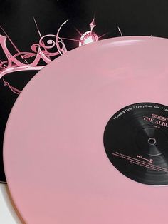 a pink vinyl record sitting on top of a table