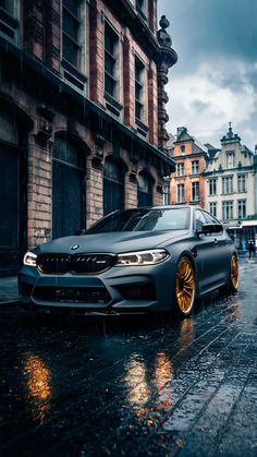 a grey car parked on the side of a wet street