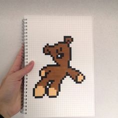 a hand holding a notebook with an image of a teddy bear on it