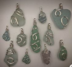 a collection of sea glass pendants with wire wrapped around them