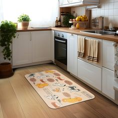 a kitchen with white cabinets and wooden floors has an area rug on the floor that is decorated with cartoon characters