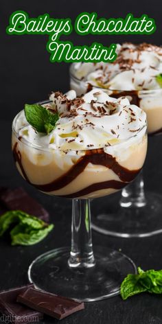 two glasses filled with chocolate martinis on top of a black table next to mint leaves