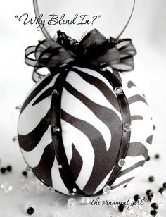 a black and white ornament with a bow on it that says why bldd