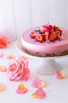 there is a cake with pink frosting and strawberries on top