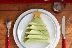 a white plate topped with green napkins and a christmas tree shaped cutout on top of it