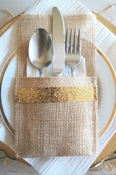 a place setting with silverware and gold sequins on linen napkins, forks and spoons