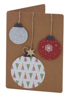 two christmas ornaments hanging from twine on brown paper