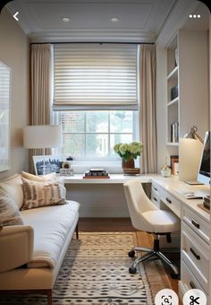 a living room filled with furniture and a window covered in shades of beige, white and brown