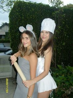 two girls dressed in bunny ears holding a baseball bat