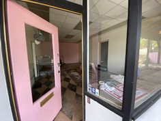 an empty room with pink doors and checkered flooring on the outside, in front of a window