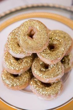 a white plate topped with donuts covered in gold glitter