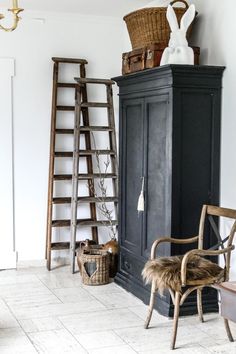 a chair sitting next to a tall black cabinet