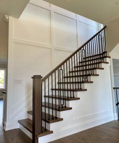 a stair case in a house with wood floors and wooden handrails that lead up to the second floor