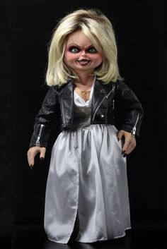 a creepy doll wearing a white dress and black leather jacket is standing in front of a black background